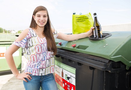 Frau beim Einwurf von Glasflaschen in einen Glascontainer